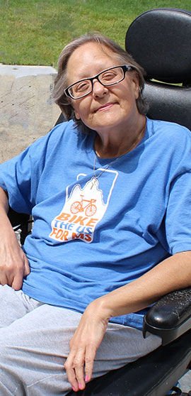 A woman smiling in a wheel chair.