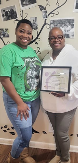 Two women with an award.