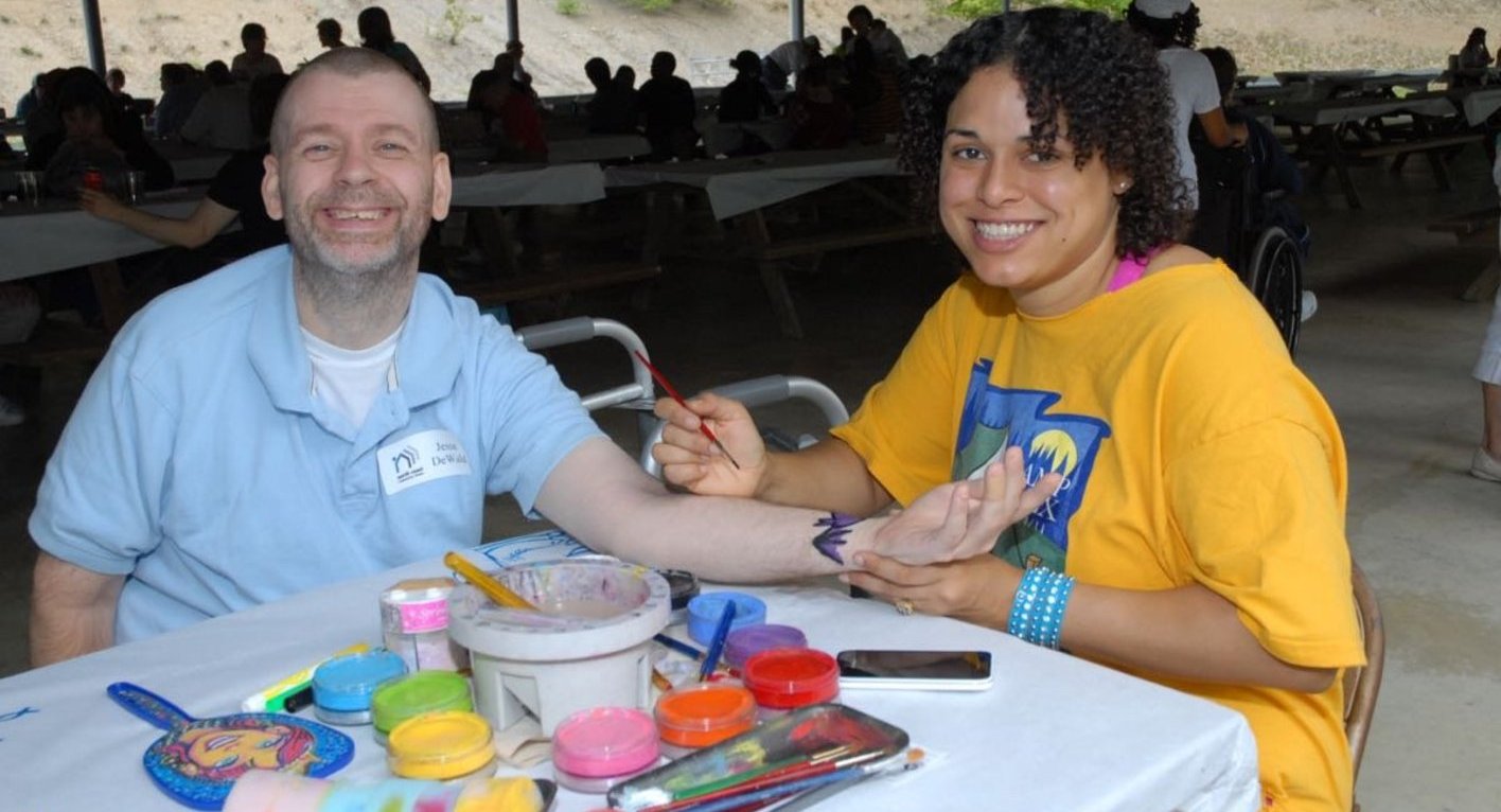 Photo of person in blue shirt getting painted.